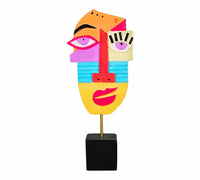 Statue artistique de visage coloré aux éléments abstraits, avec des yeux, un nez et une bouche