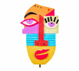 Statue artistique de visage coloré aux éléments abstraits, avec des yeux, un nez et une bouche aux formes et couleurs variées
