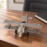 Avion décoratif en métal argenté sur un bureau en bois